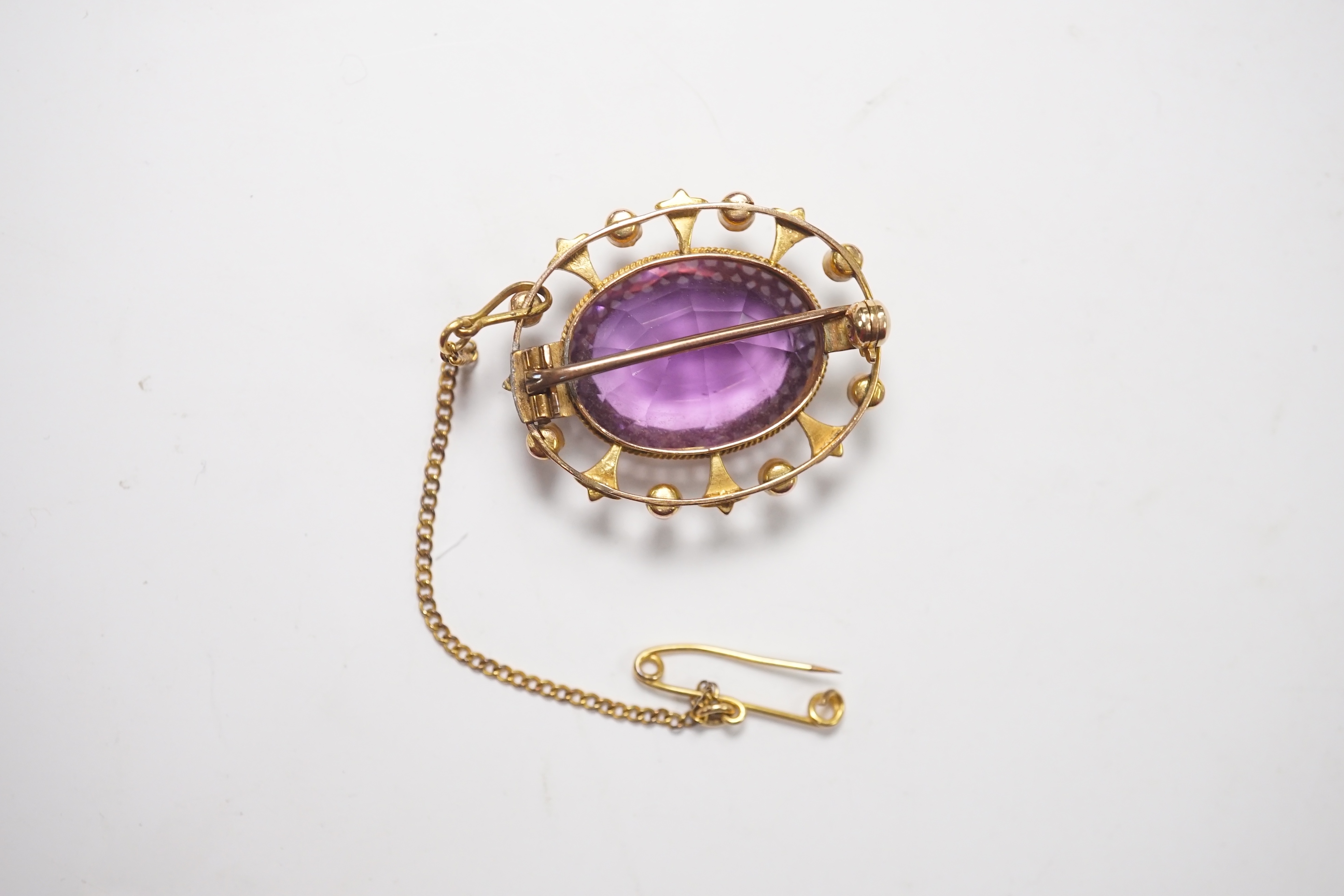 An Edwardian yellow metal, amethyst and split pearl set oval cluster brooch, 29mm, gross weight 7.2 grams. Condition - fair to good